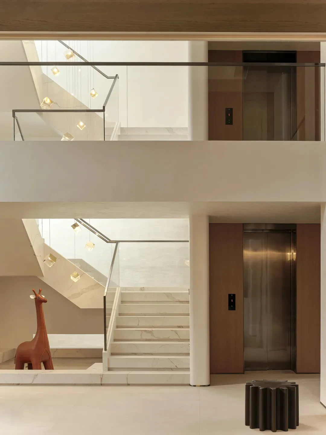 Modern lobby interior with marble stairs and pendant lights.