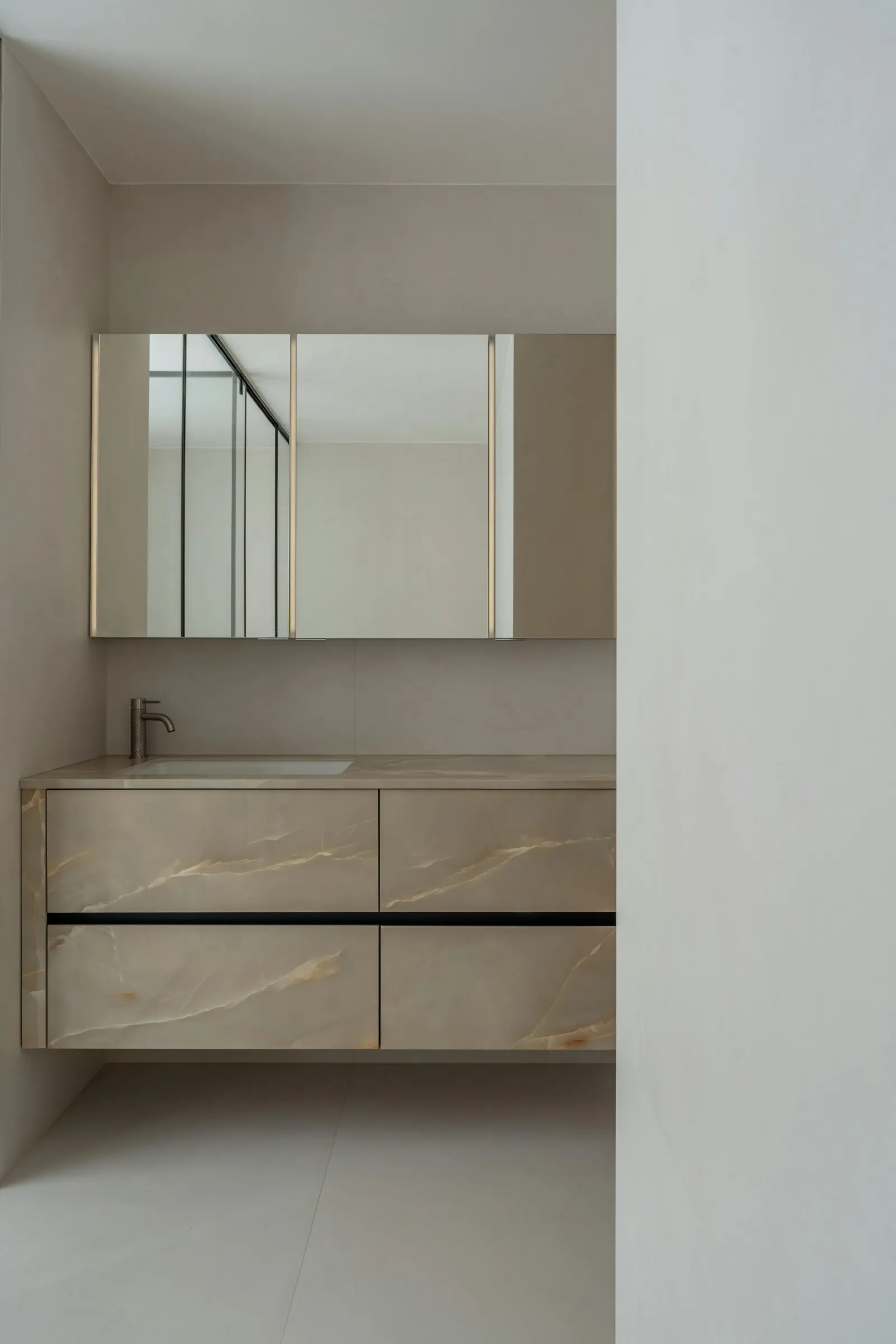 Modern bathroom with white marble countertops, a white sink, and a mirror above