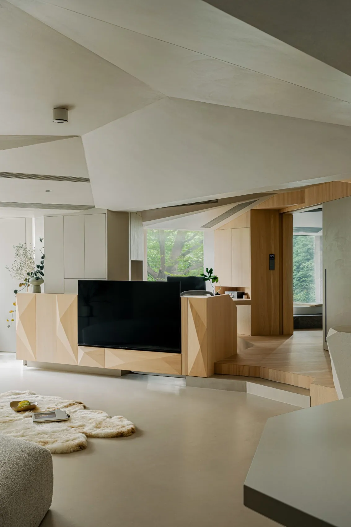 A modern minimalist living room featuring natural wood and concrete materials.