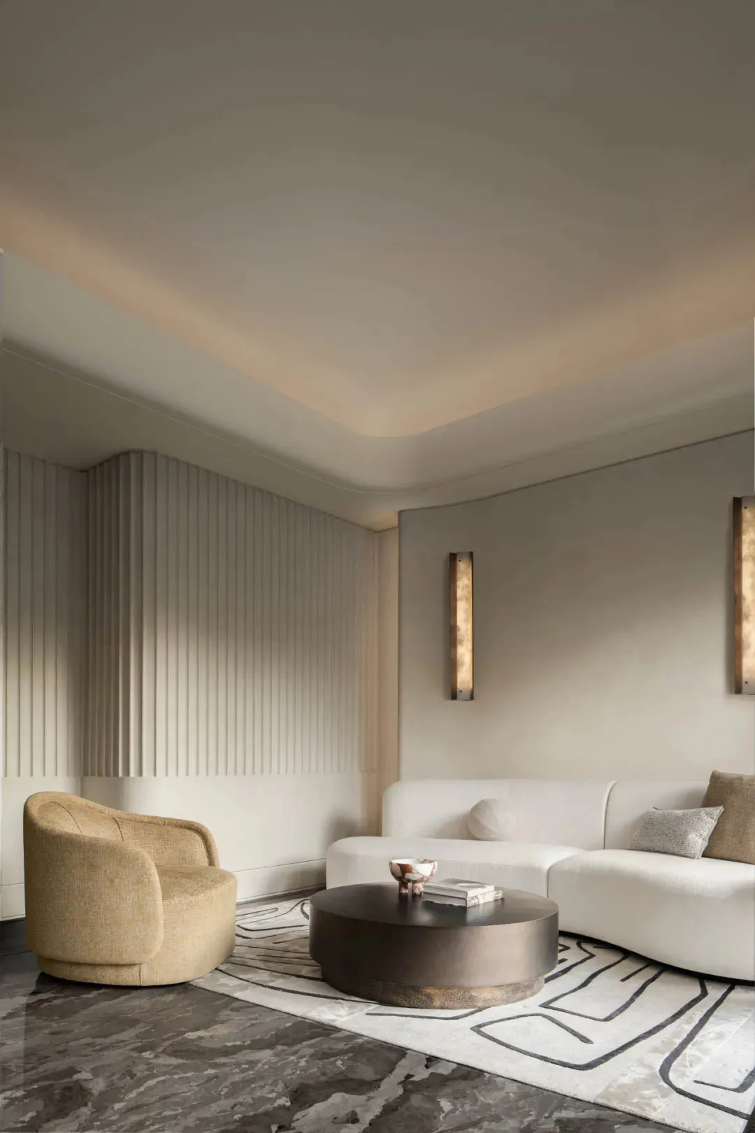 Modern living room with a curved white sofa, round coffee table, and neutral-toned wall and floor treatments.