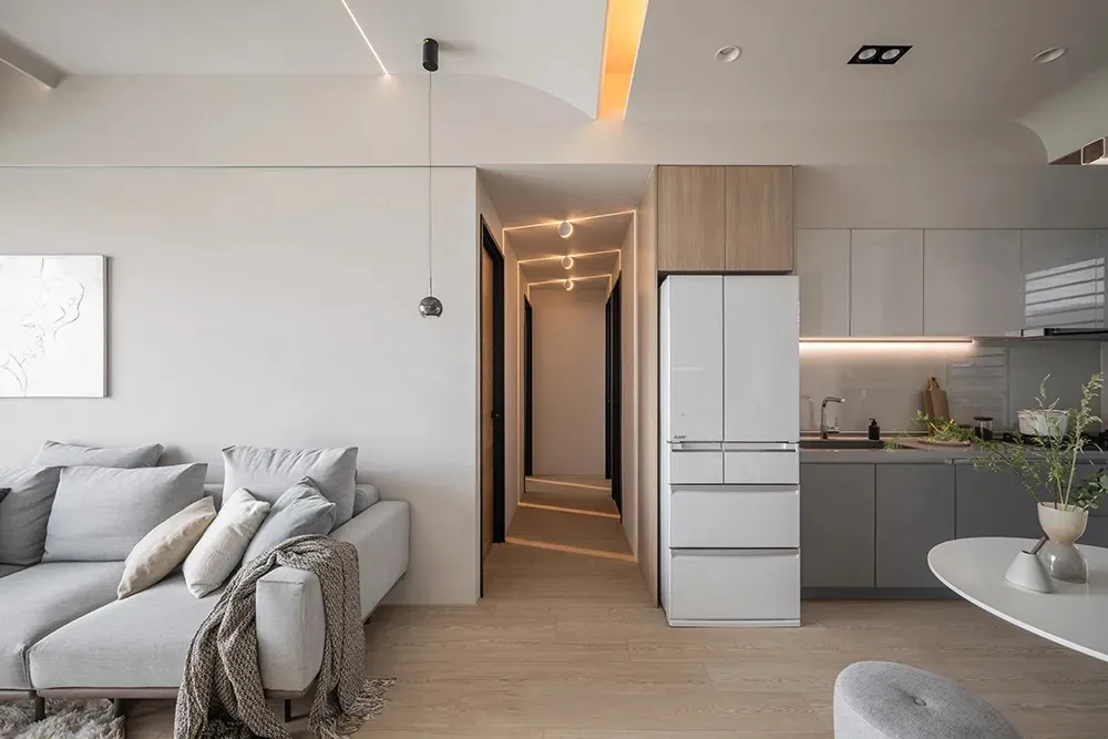 Modern residential kitchen featuring minimalist design elements, wood finishes, and white appliances.