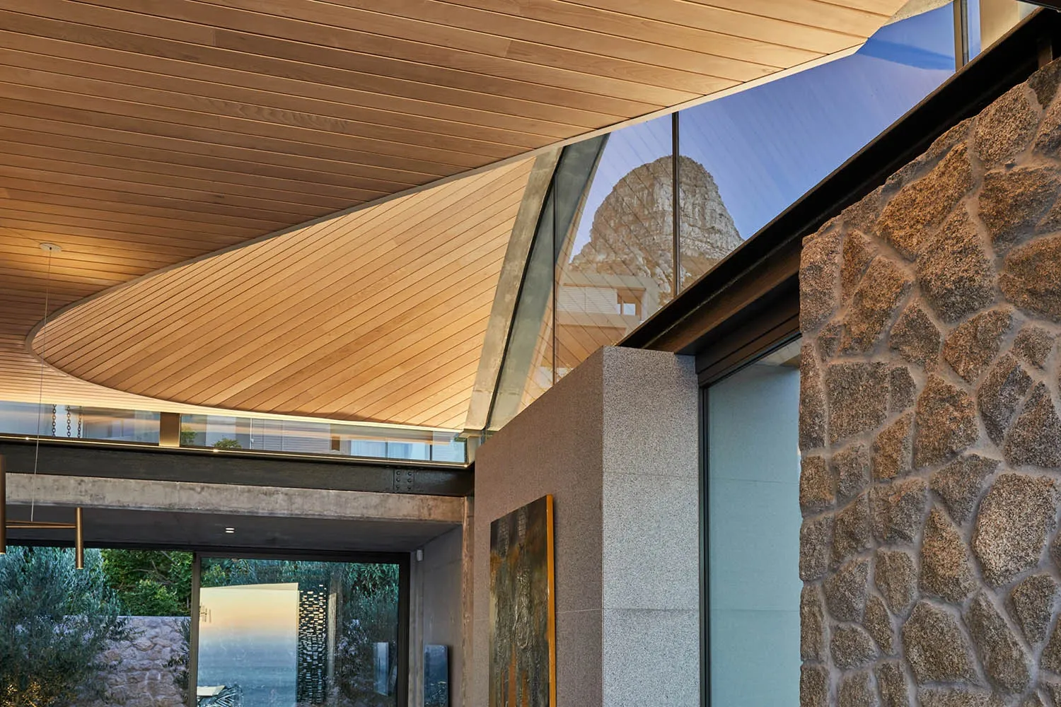 Modern residential interior featuring wood, glass, concrete, and stone materials