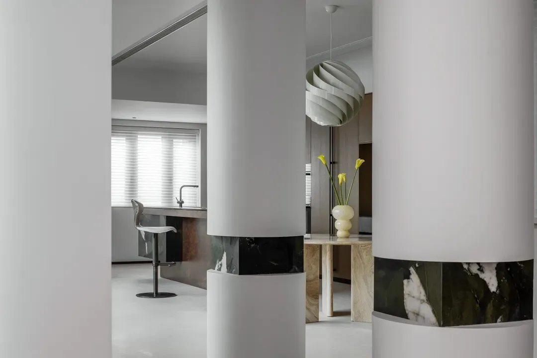 Modern kitchen featuring marble countertops and concrete flooring.
