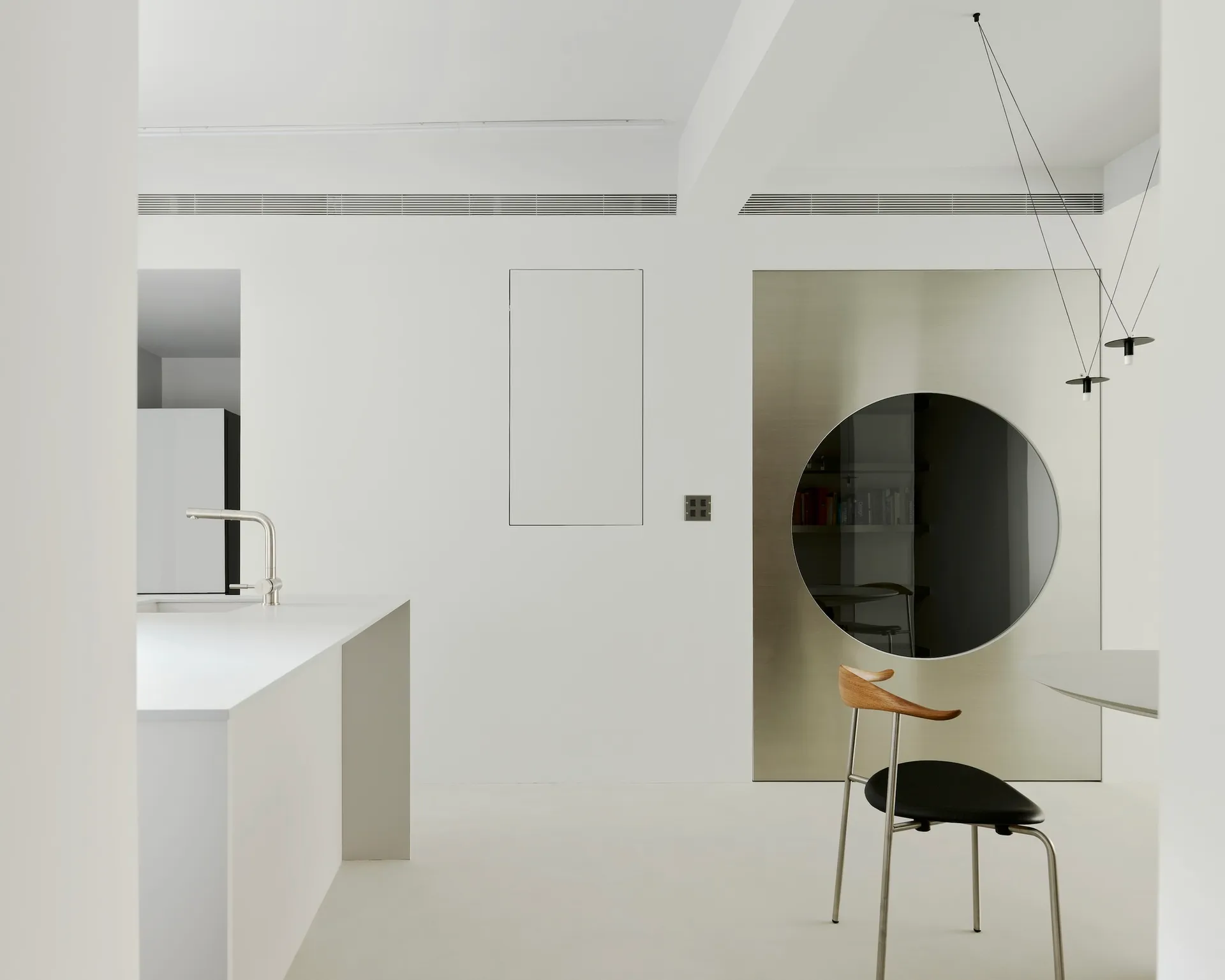 Modern minimalist kitchen with sleek white cabinets, glass backsplash, and metallic accents.