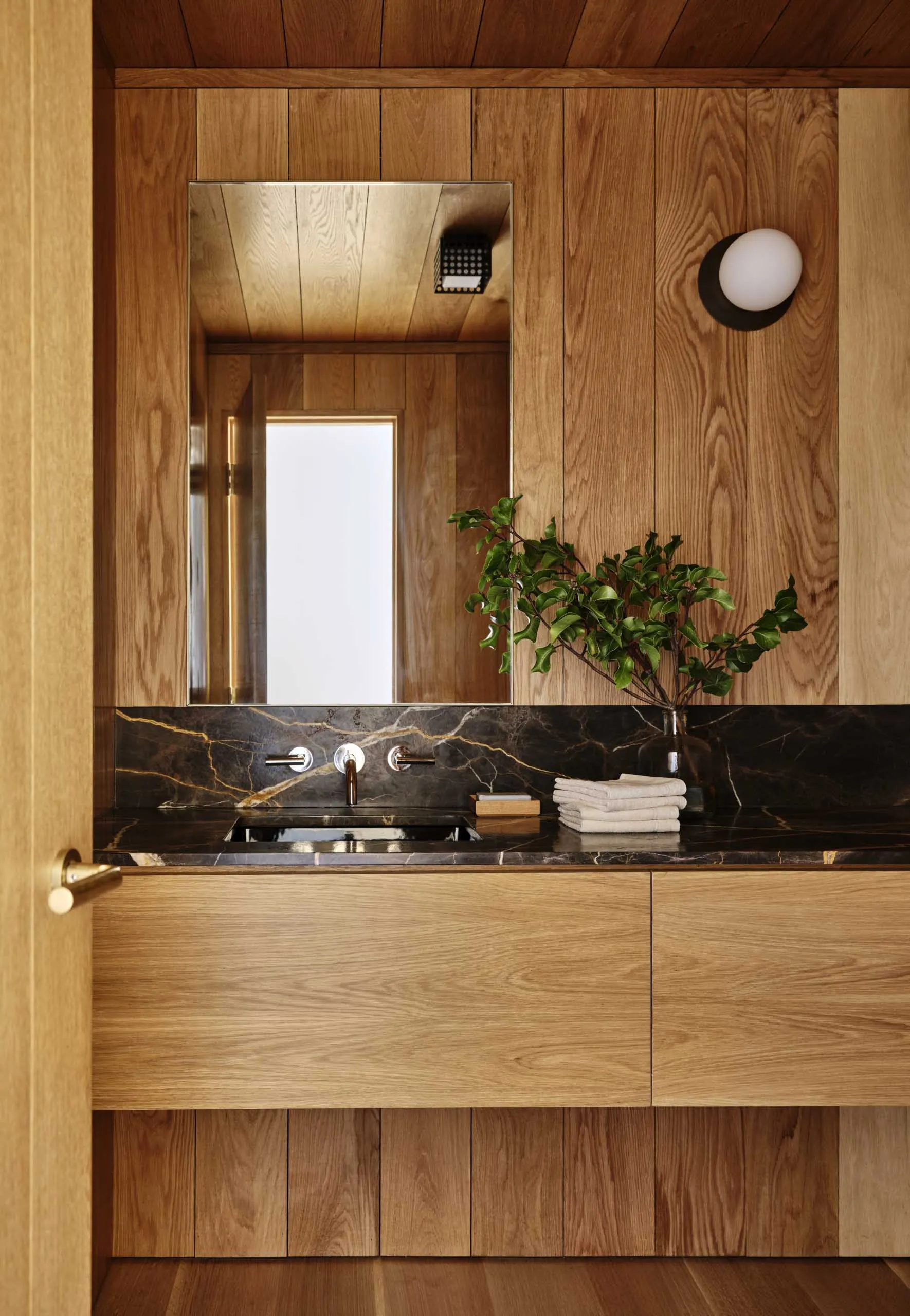 Minimalist bathroom featuring a marble countertop and wooden accents.