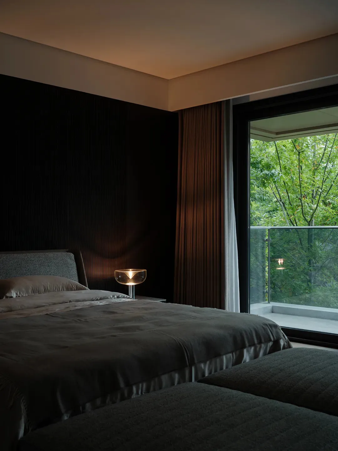 A modern bedroom featuring a textured accent wall and a soft, inviting bed.