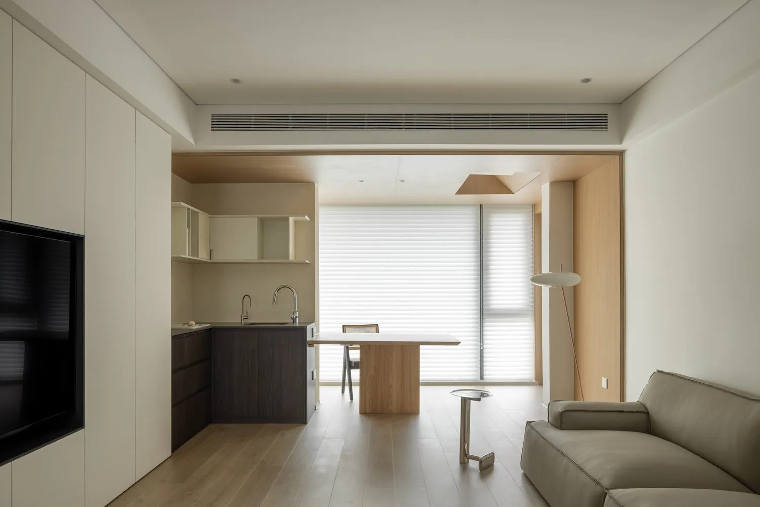 Modern minimalist kitchen with white cabinets, wooden accents, and glass elements.