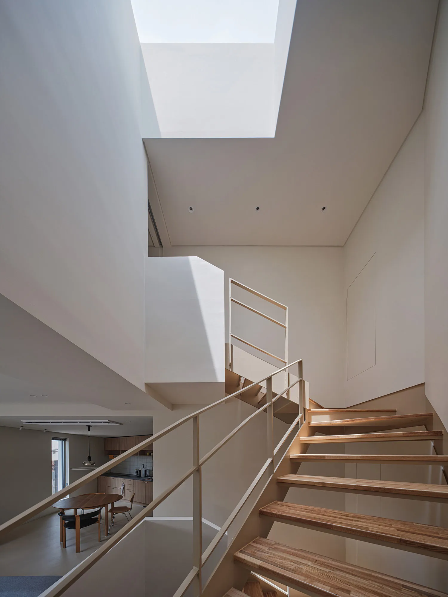 Modern, light-filled staircase with wood paneling and a skylight