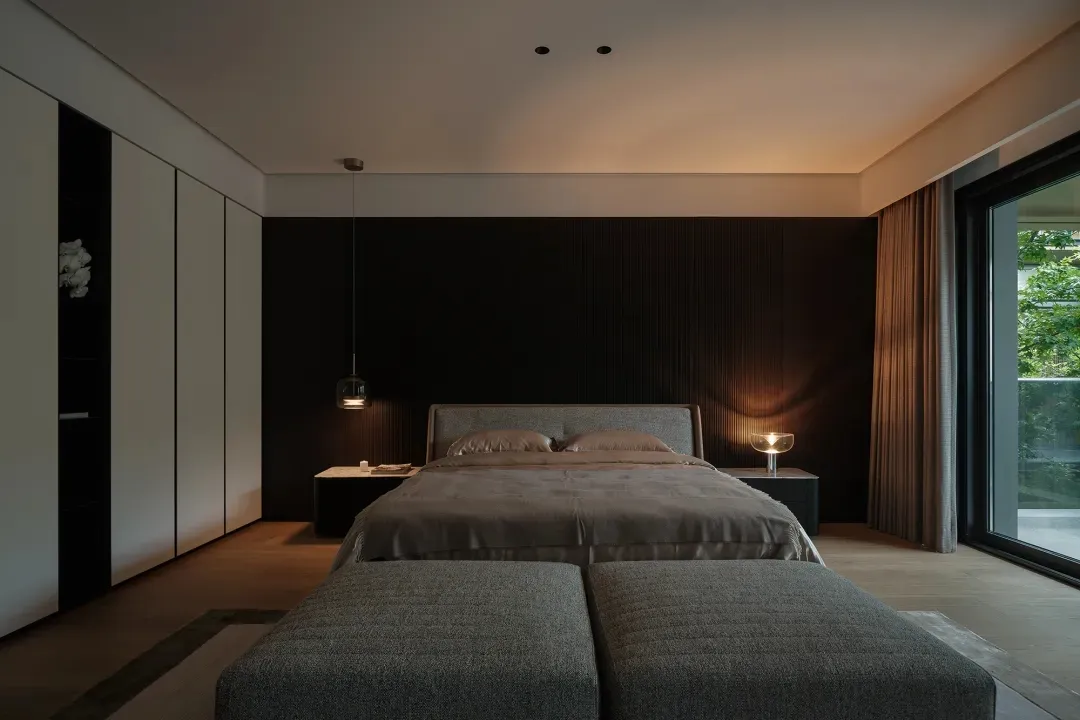 Contemporary bedroom interior with minimalist design elements, featuring a bed with a concrete headboard, grey upholstered be