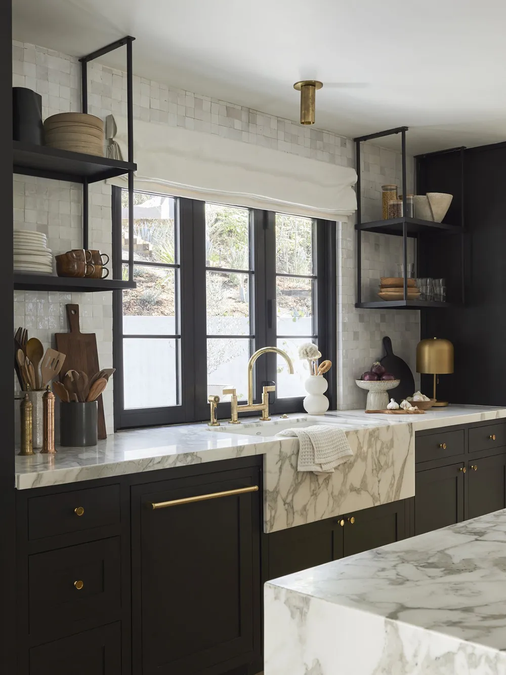 Modern minimalist kitchen featuring a marble countertop, brass fixtures, and matte-black cabinets.