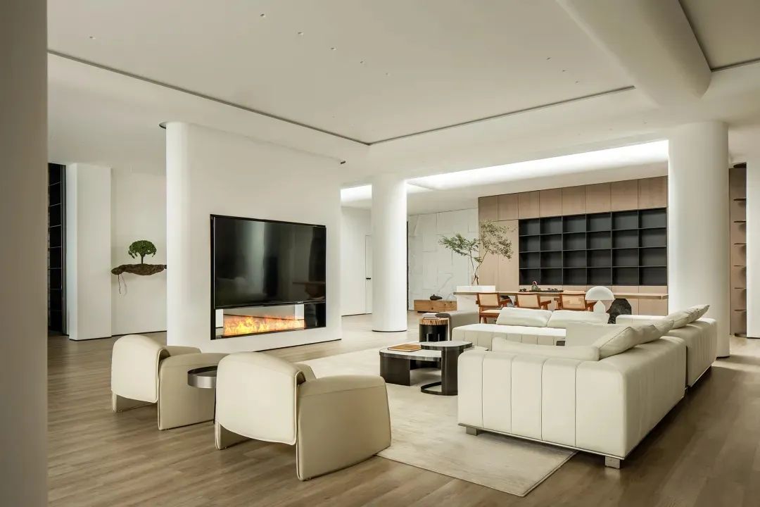 Contemporary living room with white furniture, minimalist design, and a fireplace.