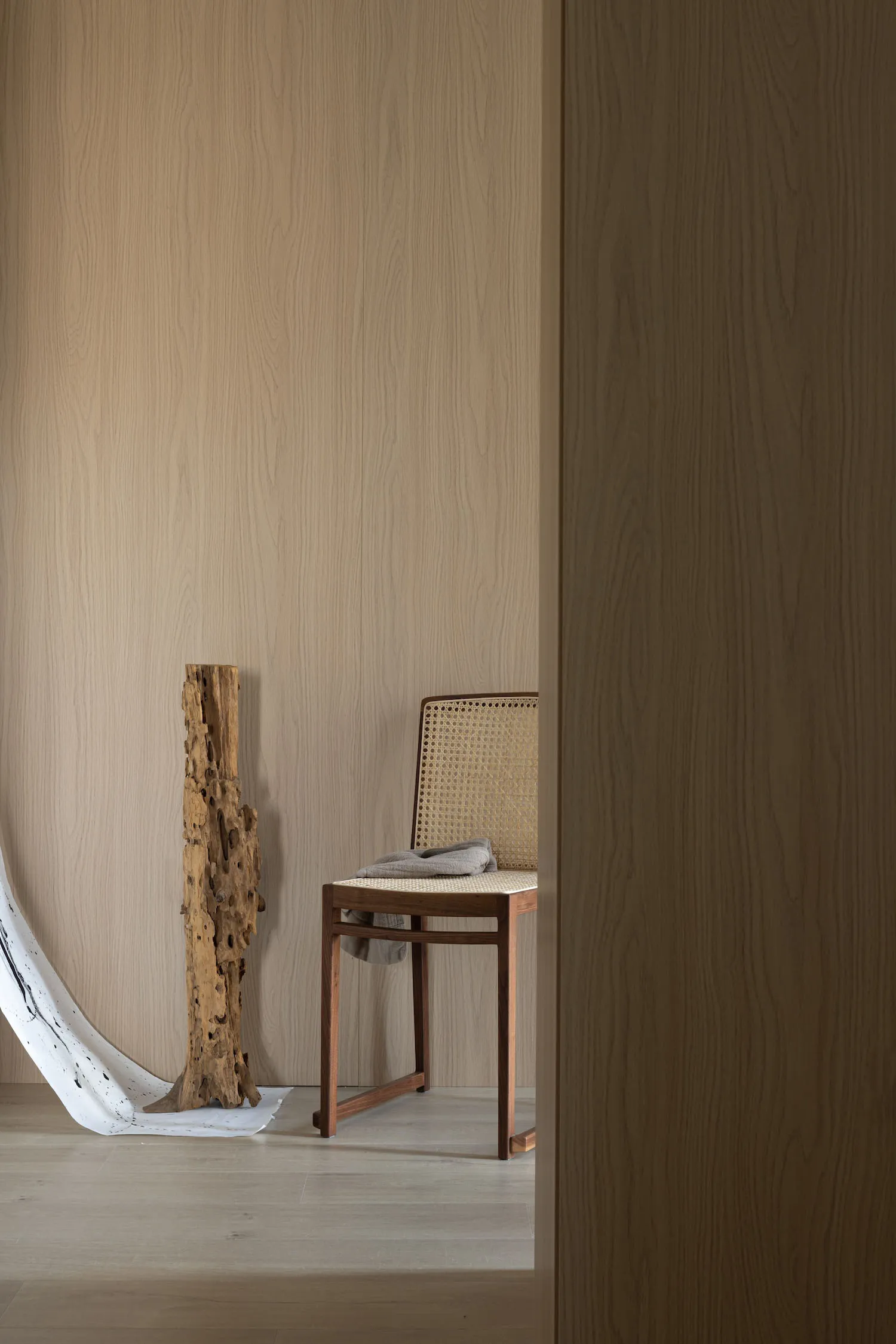 A minimalist, modern interior space featuring a wooden texture wall and floor.