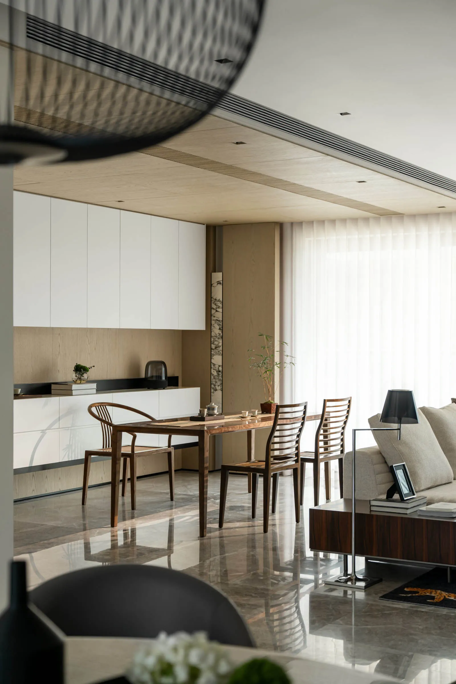 A modern living and dining room featuring marble surfaces and contemporary furniture.