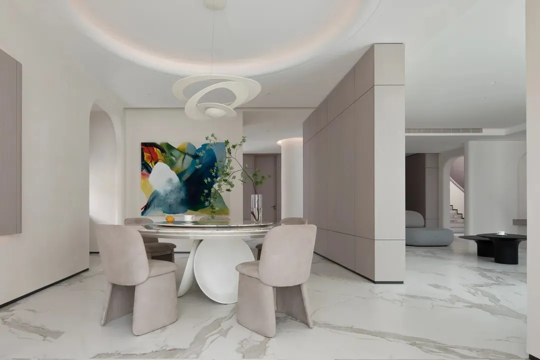 A modern living room with marble floors, a marble table, and marble countertops, featuring contemporary furniture and a minim