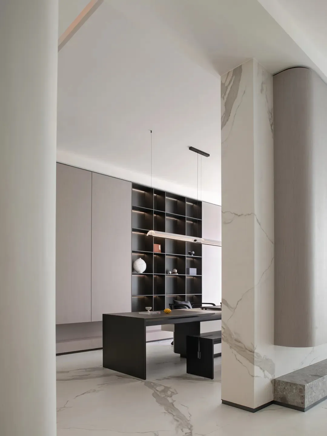A modern minimalist office space featuring a combination of marble and concrete materials.