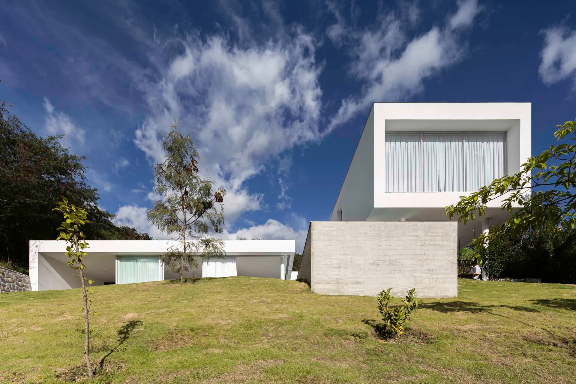 A modern residential exterior with concrete walls and glass windows.