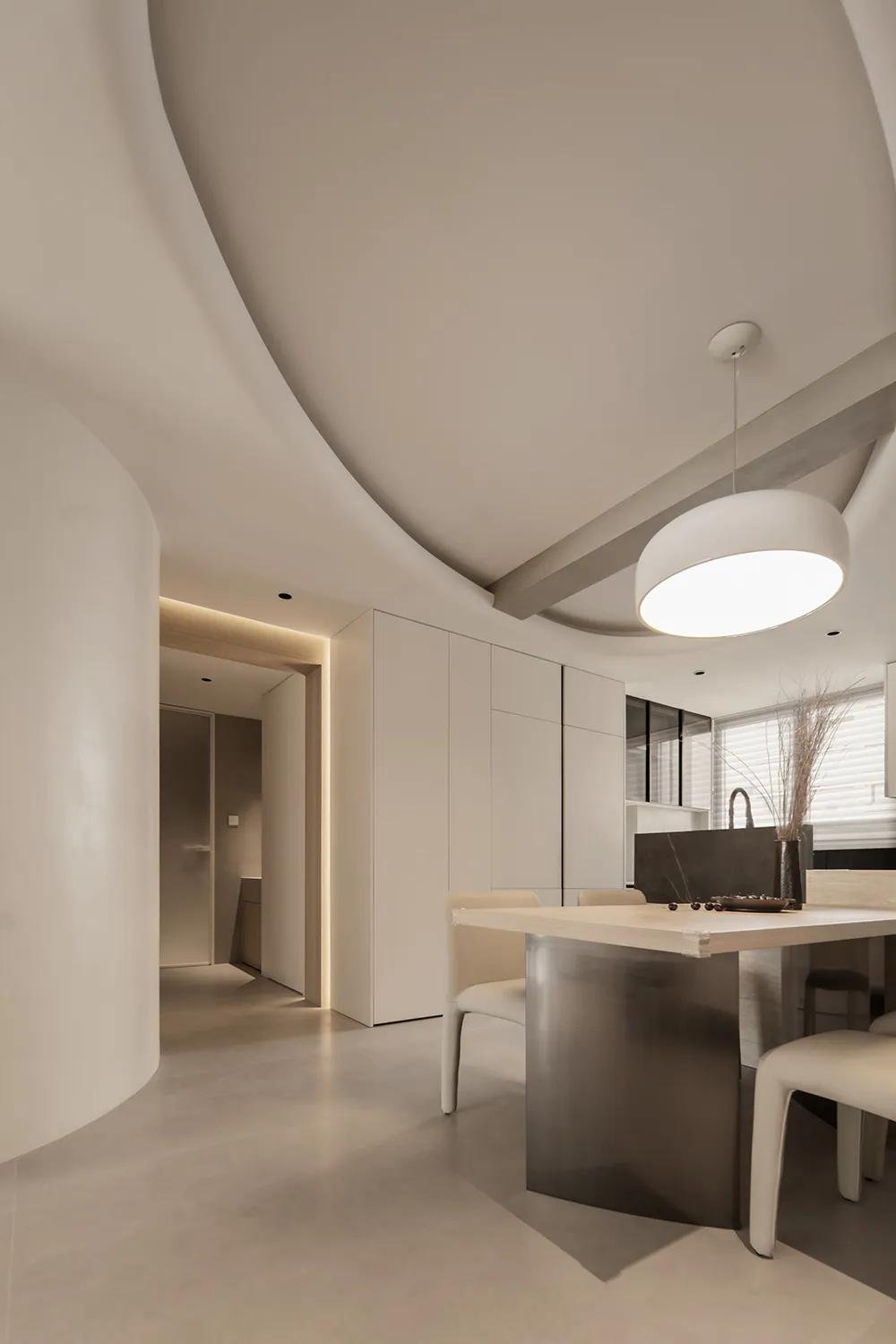A minimalist interior space featuring a concrete dining table and modern furniture.