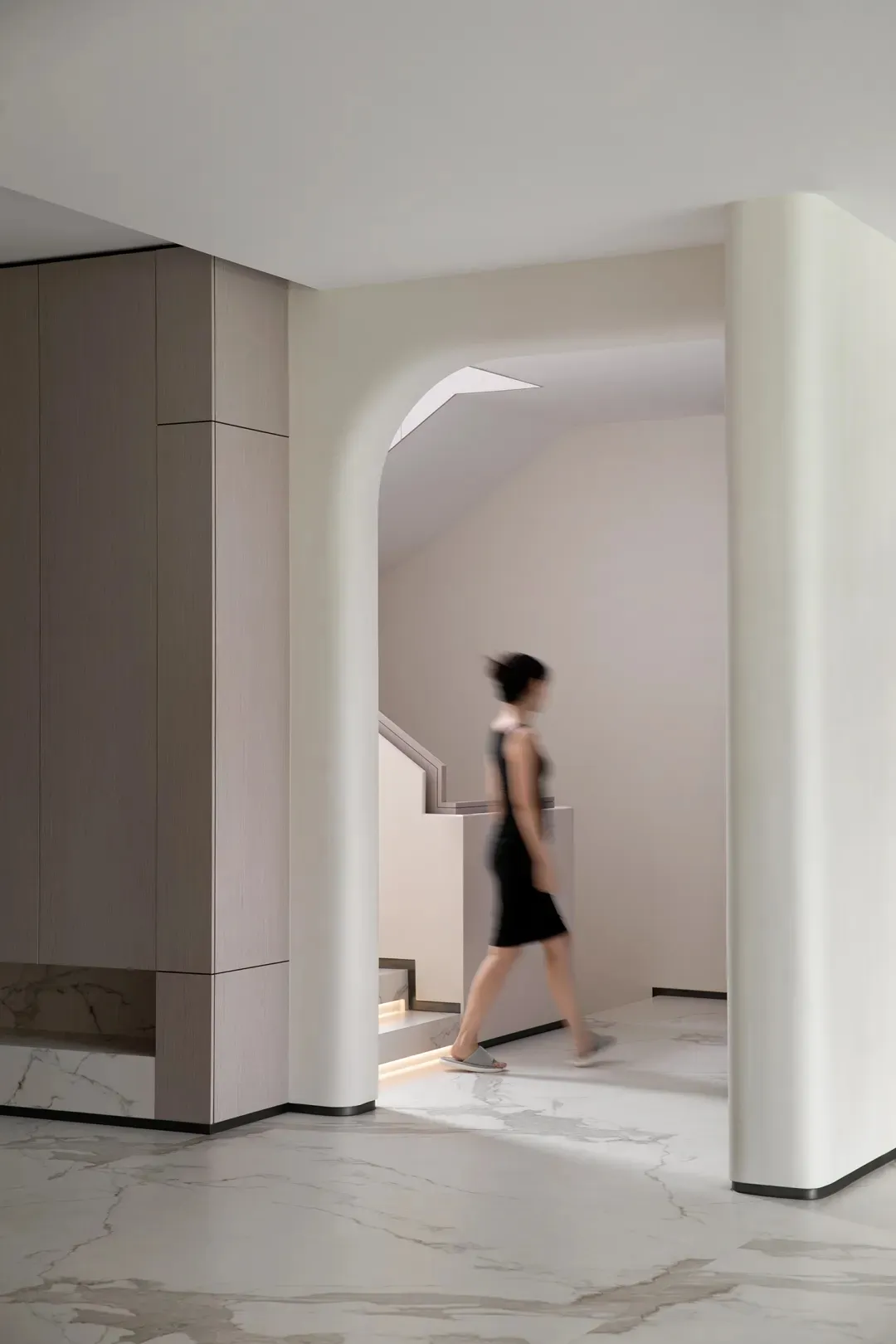 A minimalist interior space featuring marble flooring and striped wooden elements.