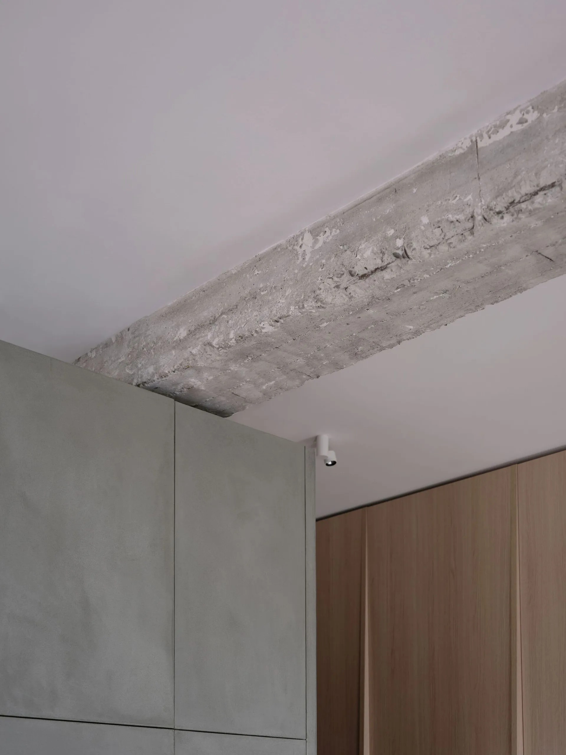 Modern kitchen interior with concrete walls, white cabinets, and minimalist design