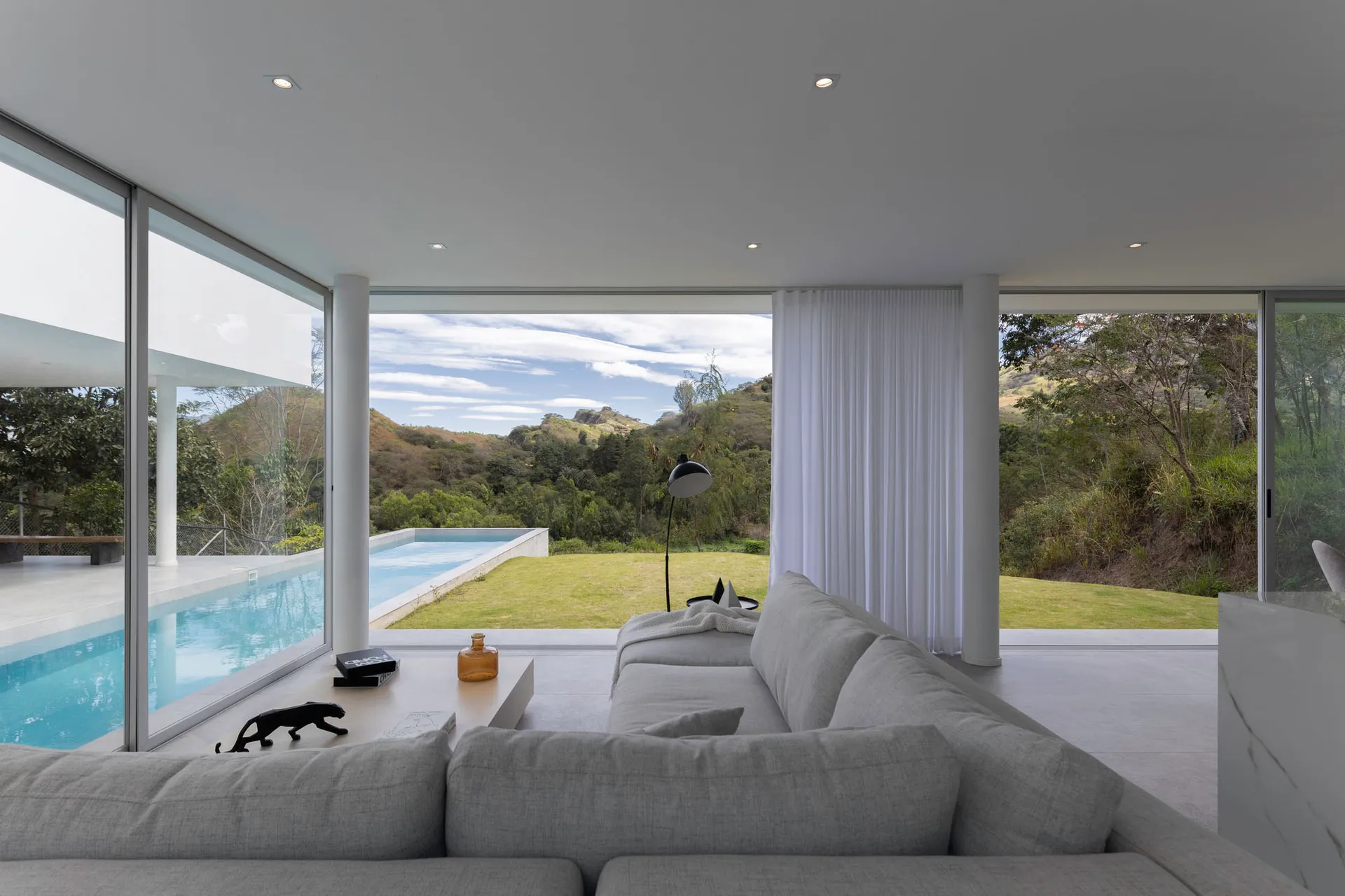Modern white-painted interior with furniture and a view of a spa pool.