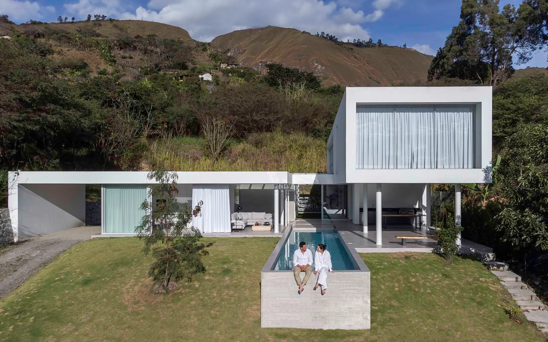 A modern residential house with a concrete exterior and a rooftop garden.