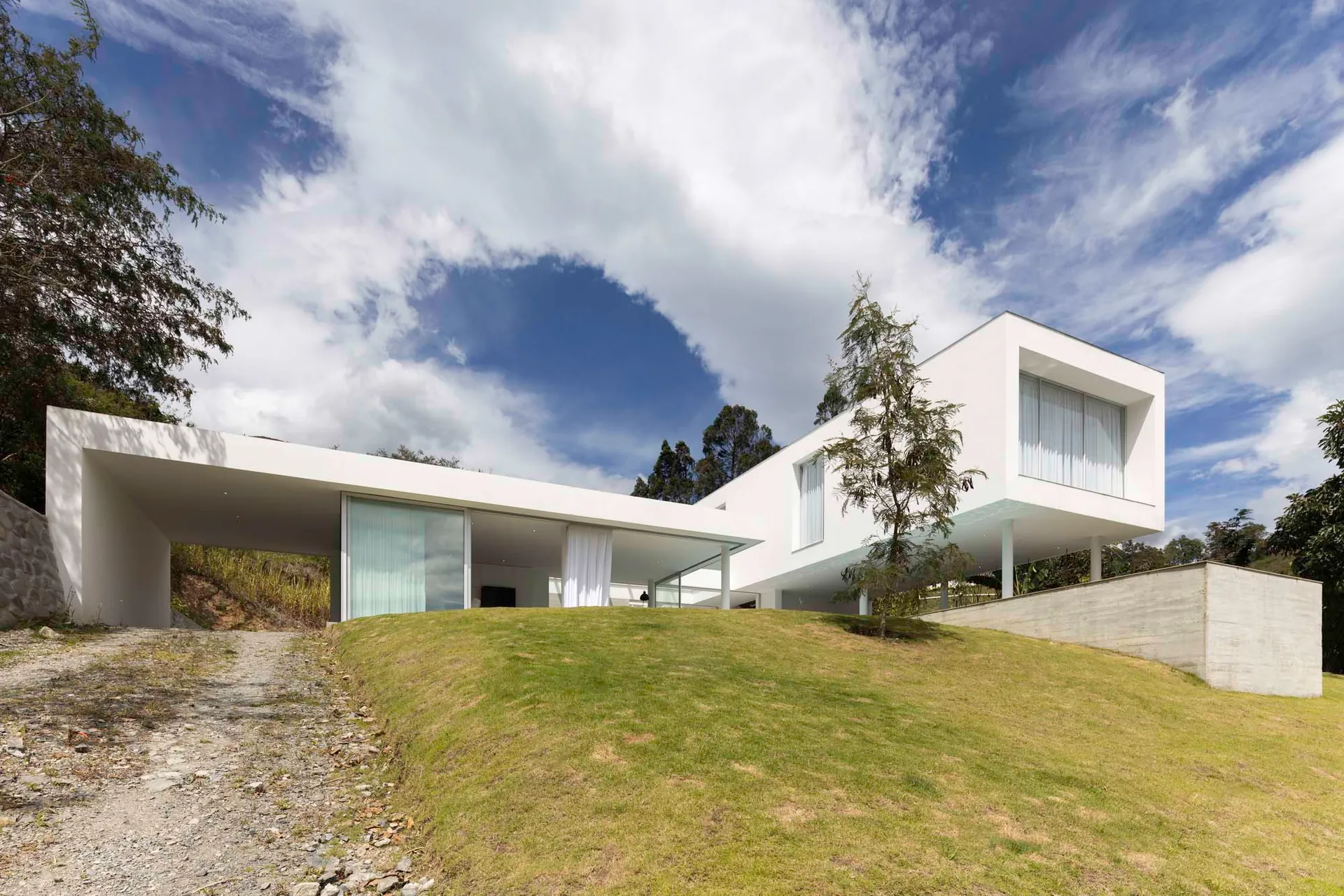A modern white concrete home with large glass windows and a minimalist design.