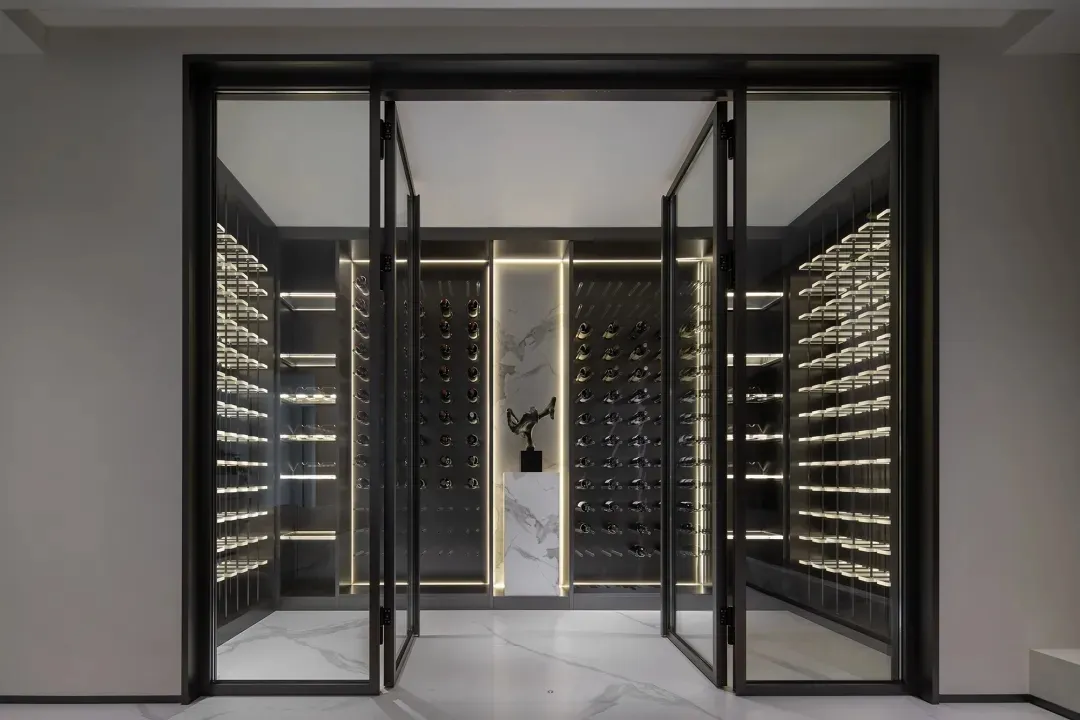 An industrial-style wine cellar with illuminated glass shelves and a central display area.
