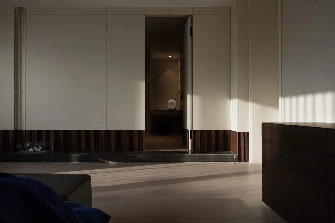 Modern minimalist interior design featuring wooden flooring and marble columns.