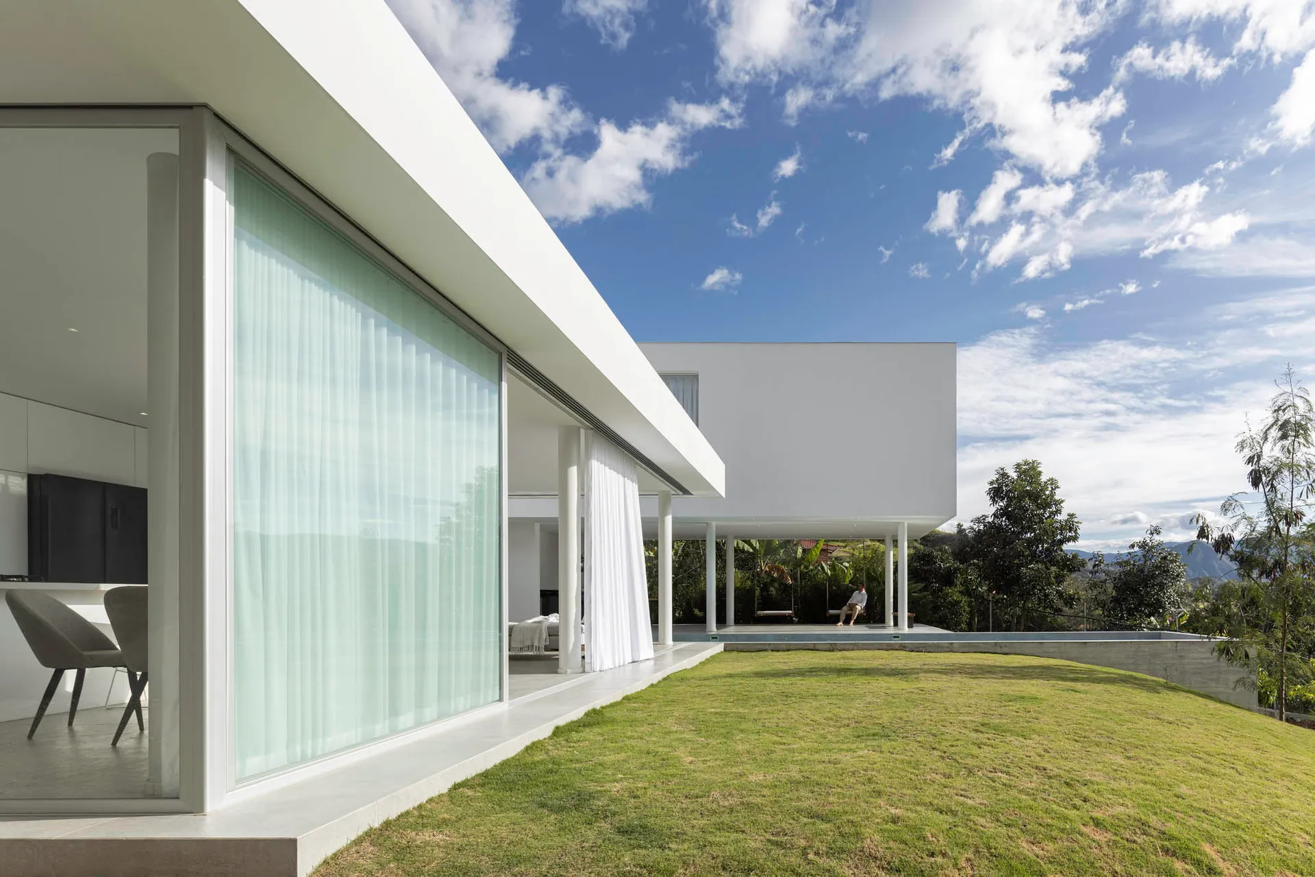 A modern exterior with large glass windows and concrete columns.