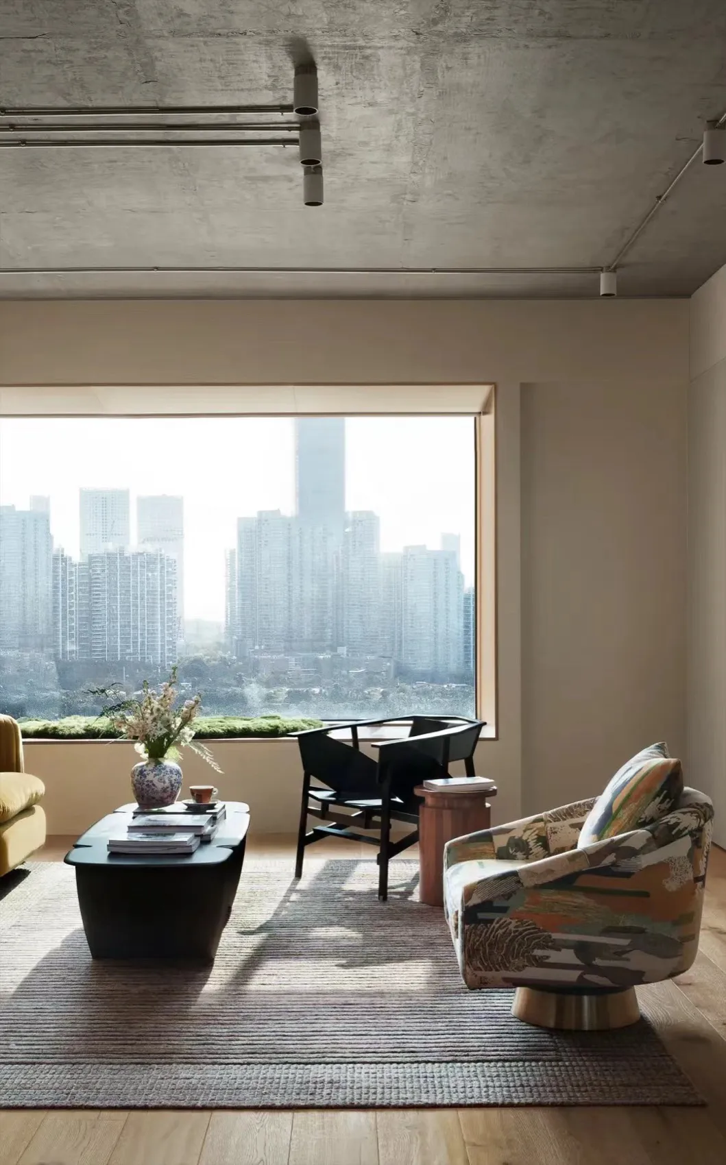 現代客廳,混凝土牆面搭配落地窗,窗外可見城市景觀。