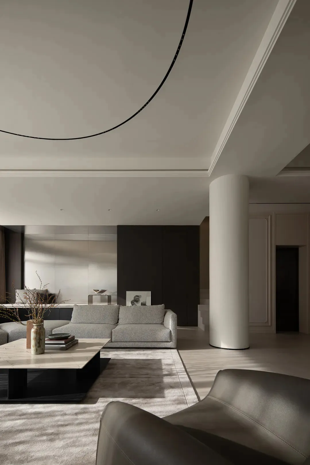 Modern living room featuring minimalist design with concrete walls, marble coffee table, and leather sofa.