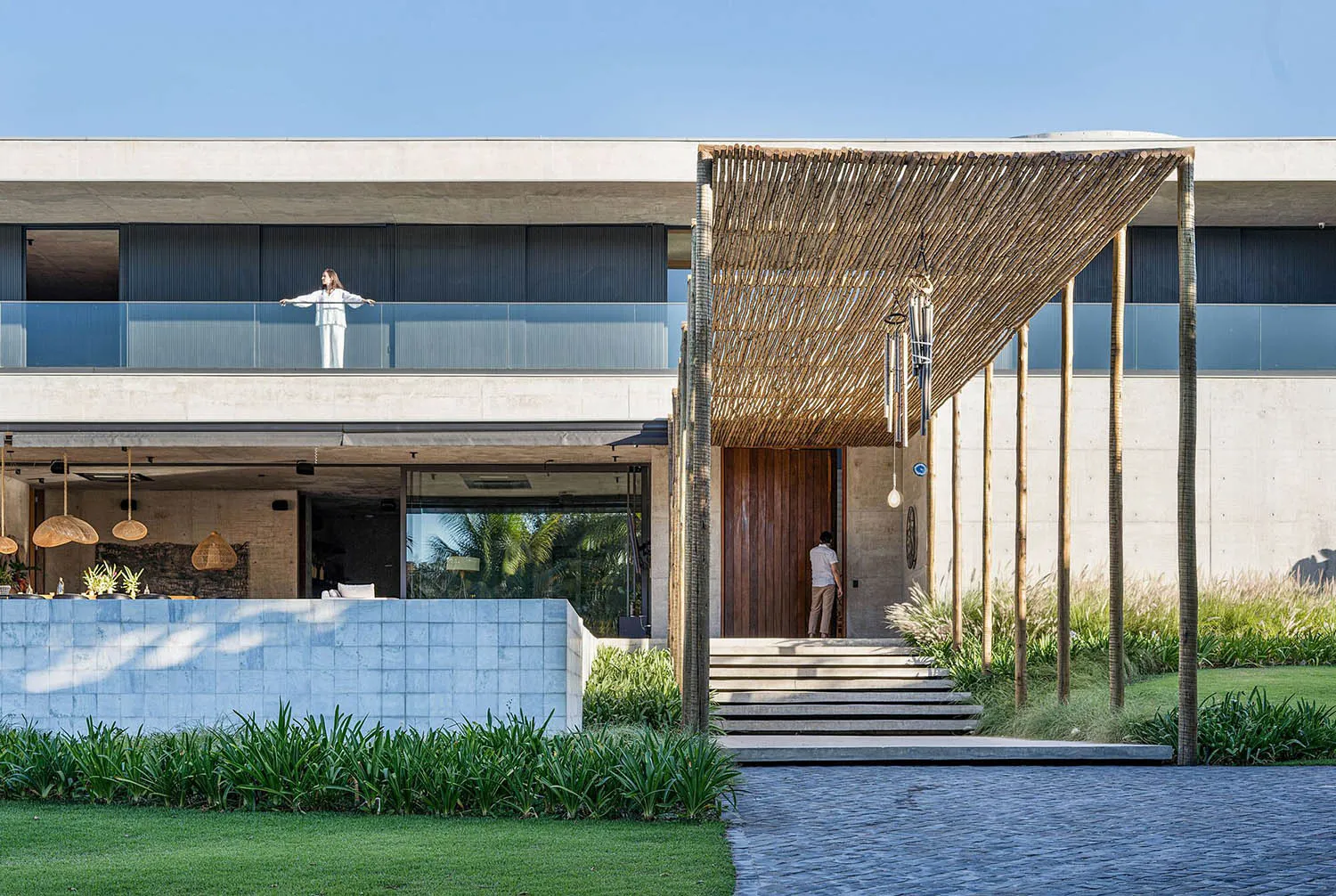 Modern residential exterior with concrete structure and large glass windows.