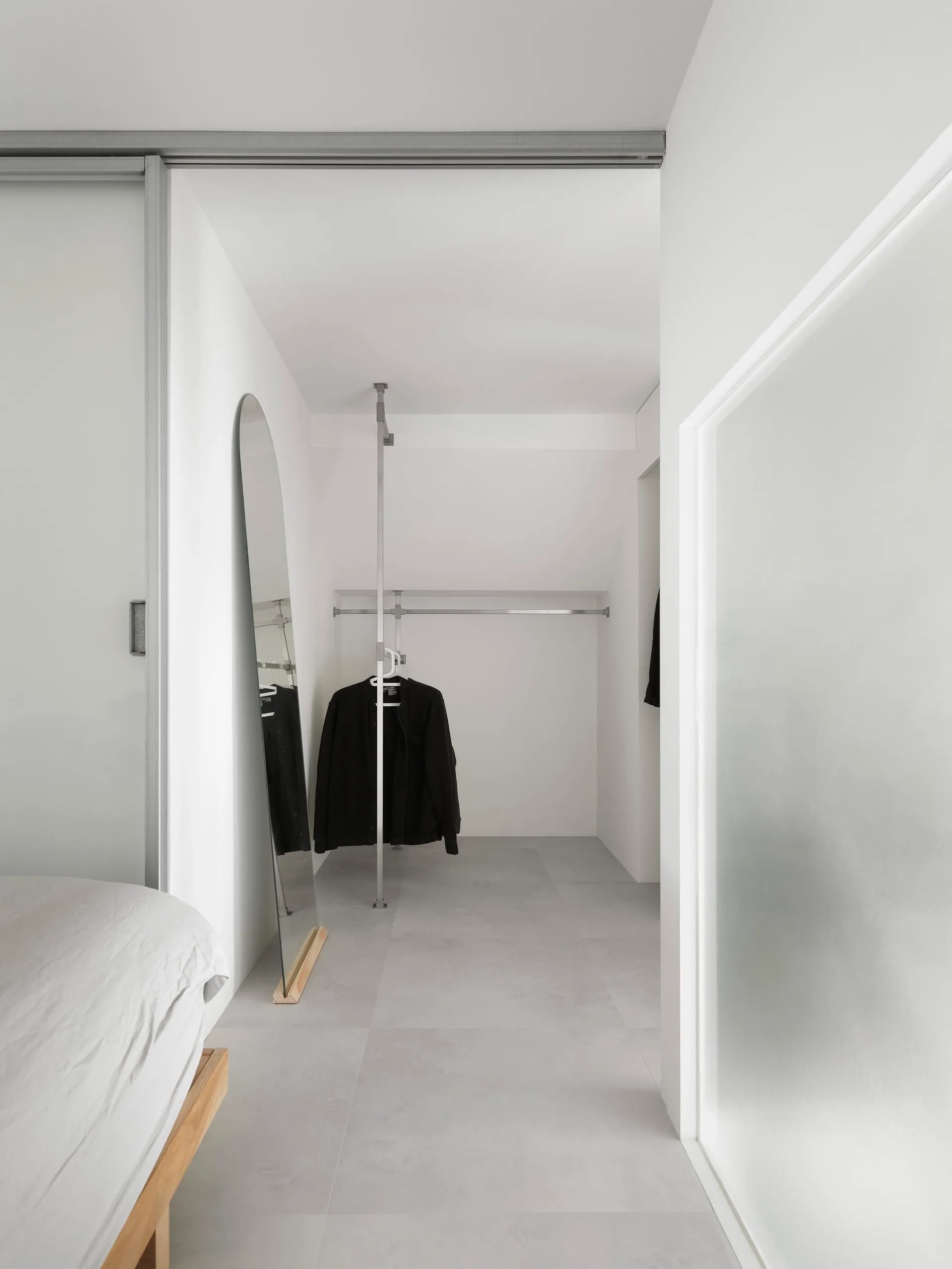 Modern minimalist closet with concrete flooring and minimalist design, showcasing sleek and functional storage solutions.