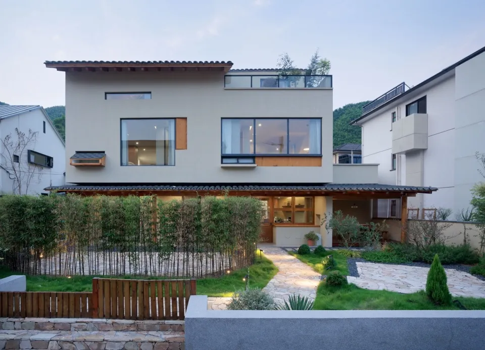 A modern residential exterior featuring concrete and glass materials.