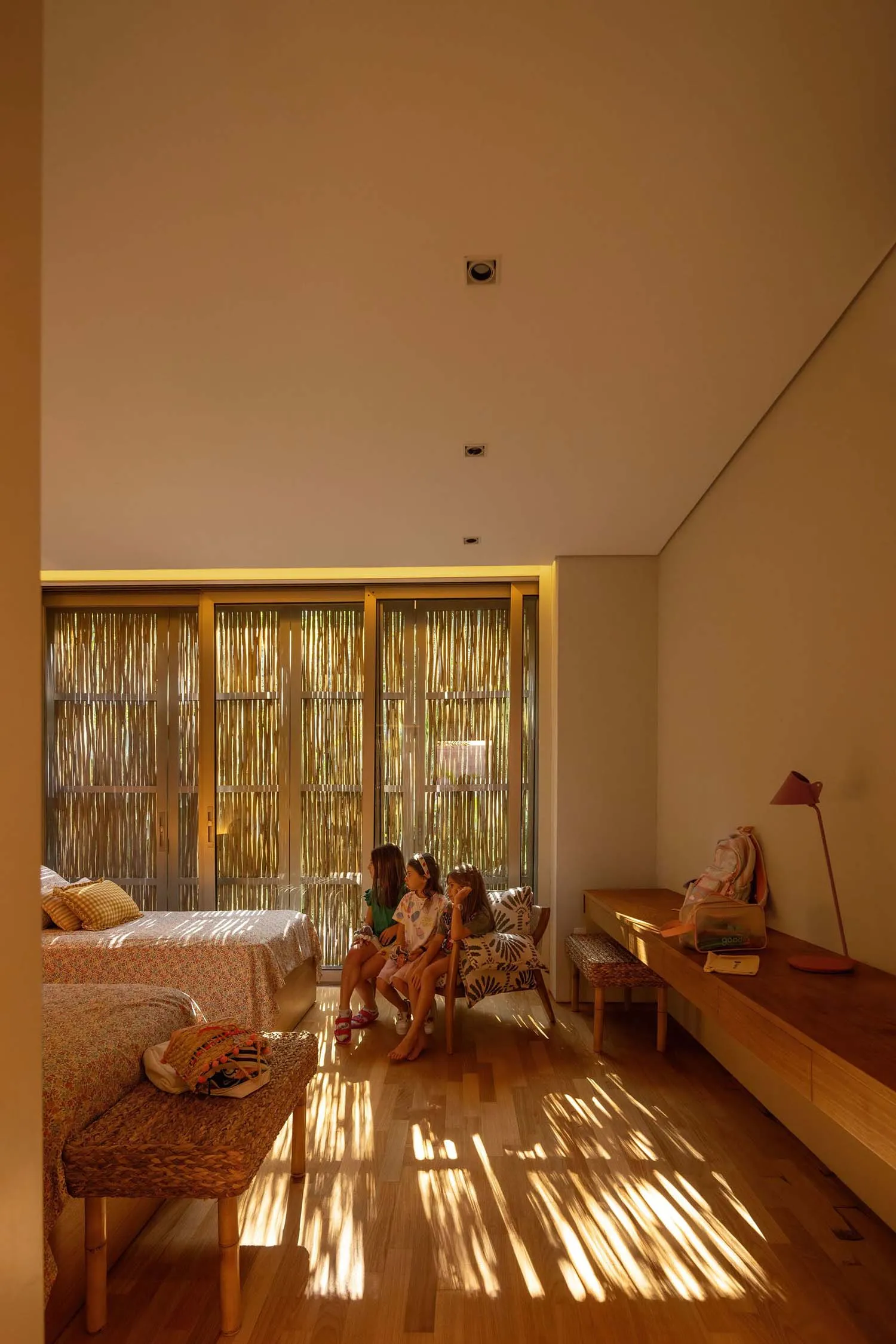 A modern bedroom featuring hardwood flooring and furniture with a minimalist design.
