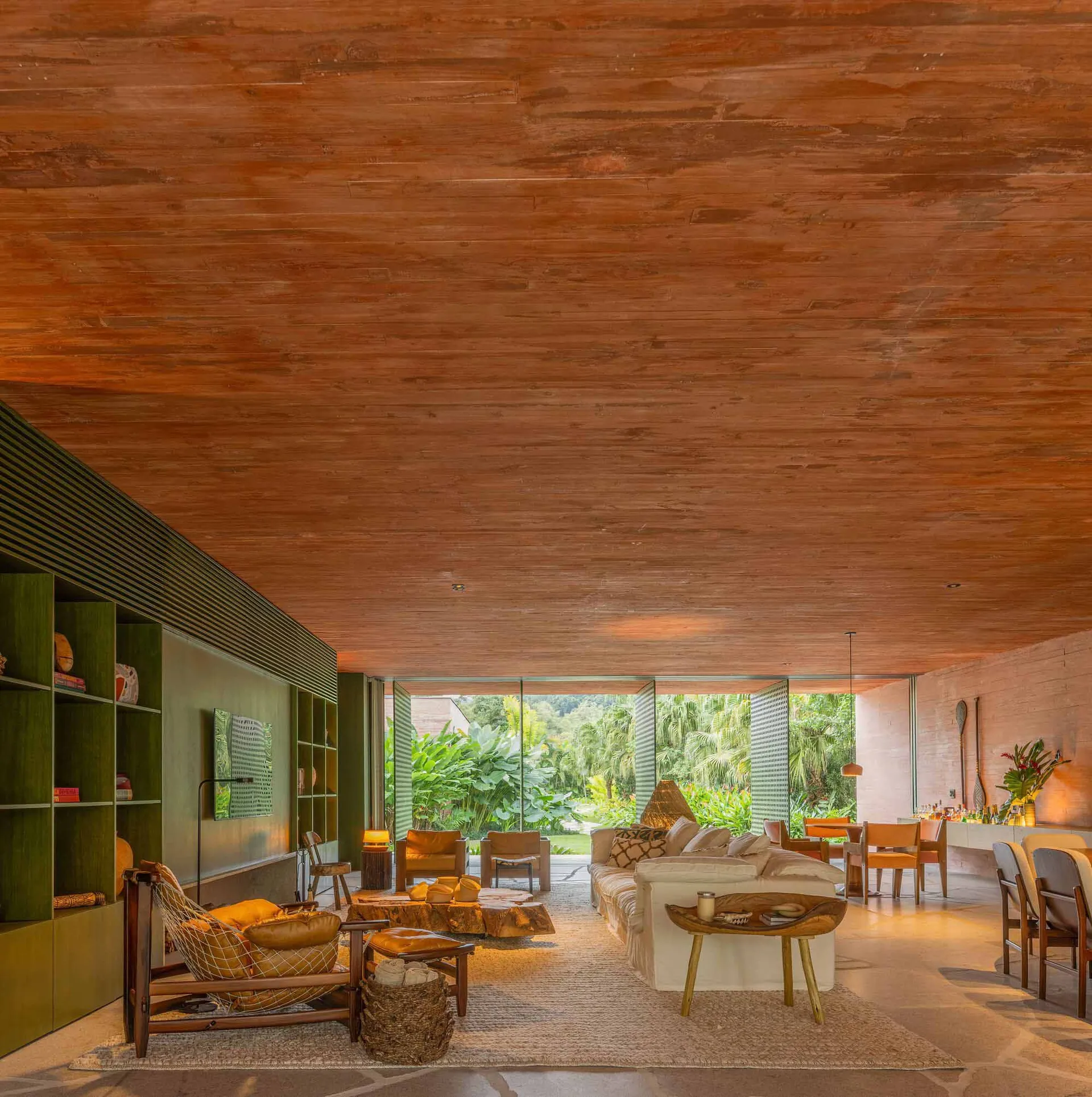 A modern living room with a wooden ceiling and a large window overlooking a lush garden.