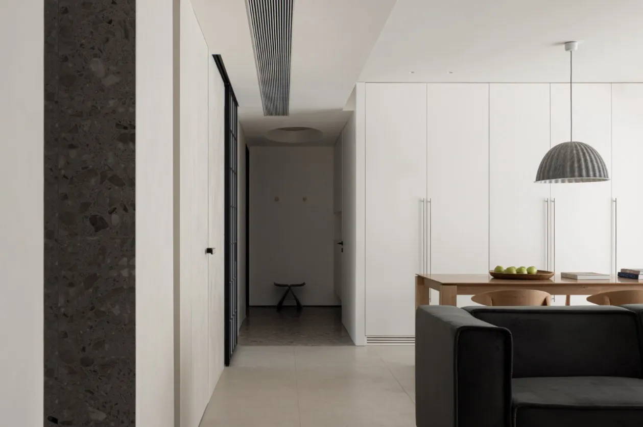 A modern living room with concrete flooring and minimalist furniture.