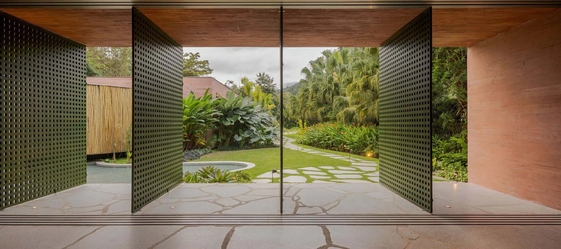 Modern residential interior with concrete floor and open view of lush green garden.