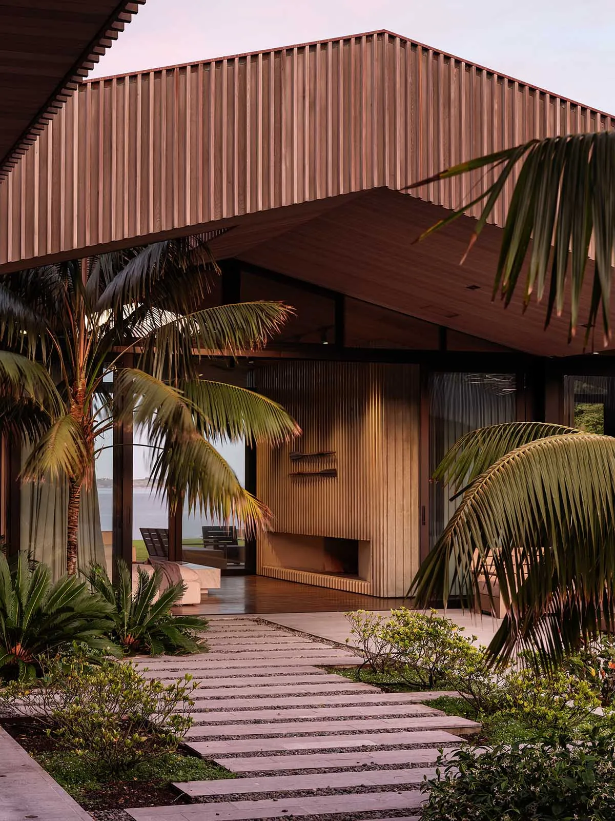 A modern outdoor space featuring wooden structures and palm trees.