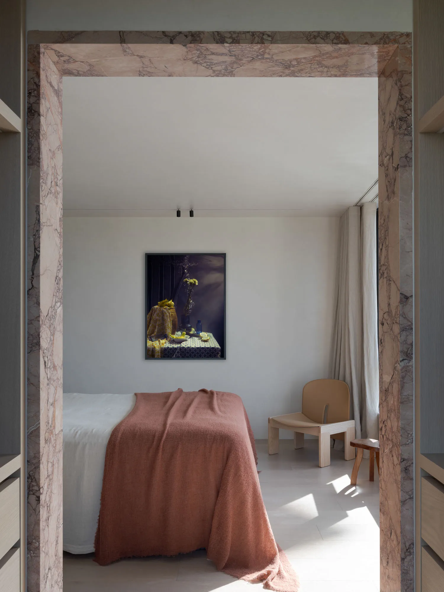 簡約臥室內有大理石點綴,以及一把木椅。