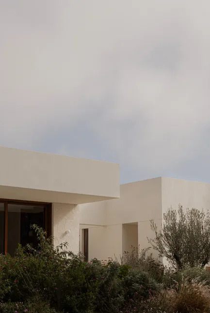 A minimalist residential exterior featuring concrete materials and a modern design.