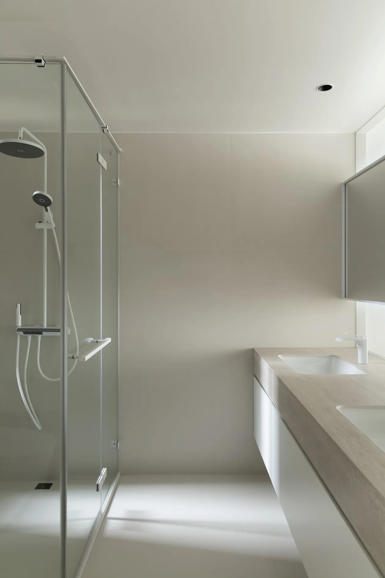 A minimalist bathroom with a concrete floor and white walls.