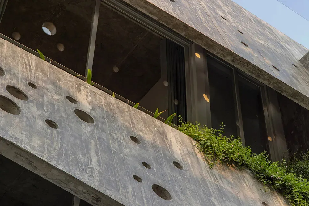 混凝土建築外觀,帶有圓形鏤空與綠色植物