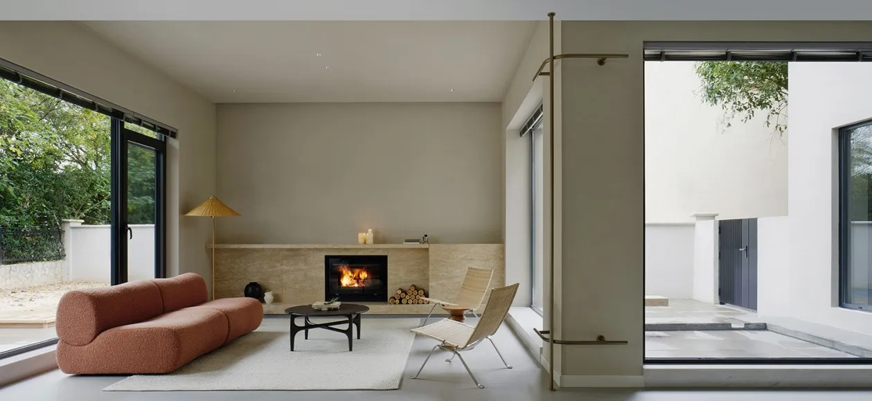 Modern living room with a fireplace, minimalistic furniture, and visible exterior wall