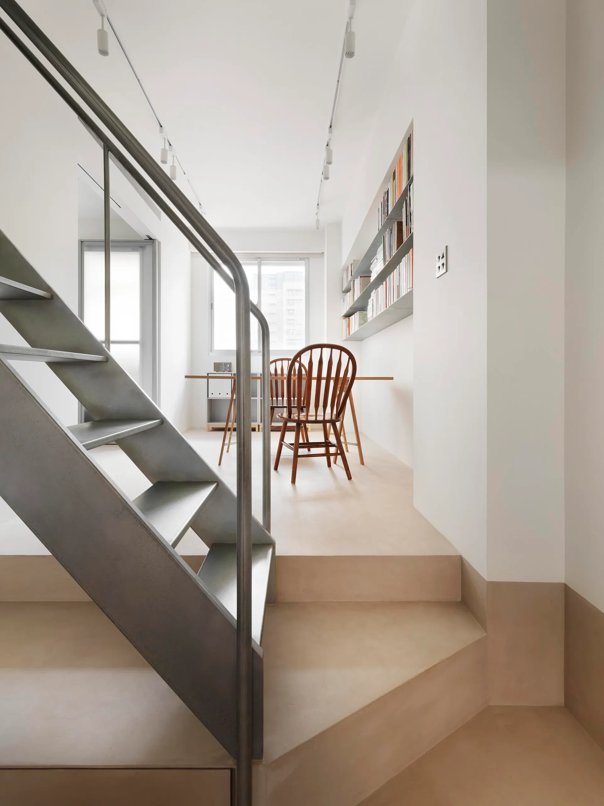 A modern living room with a concrete floor, minimalist furniture, and a large window
