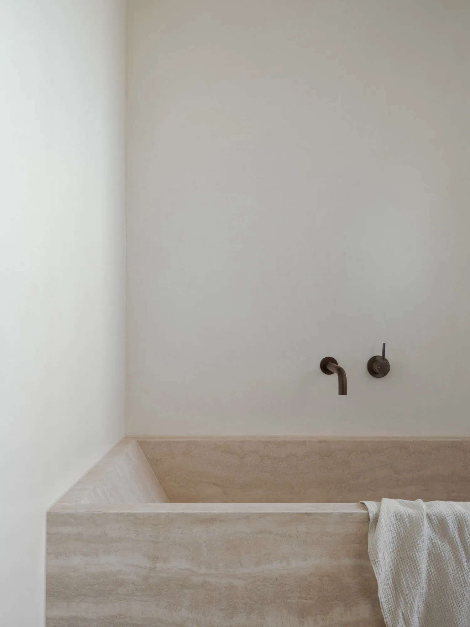 Minimalist, modern bathroom with marble and concrete finishes.