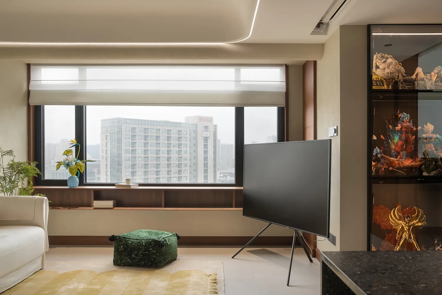 A modern living room with a concrete floor, a white couch, and a large window overlooking a cityscape.