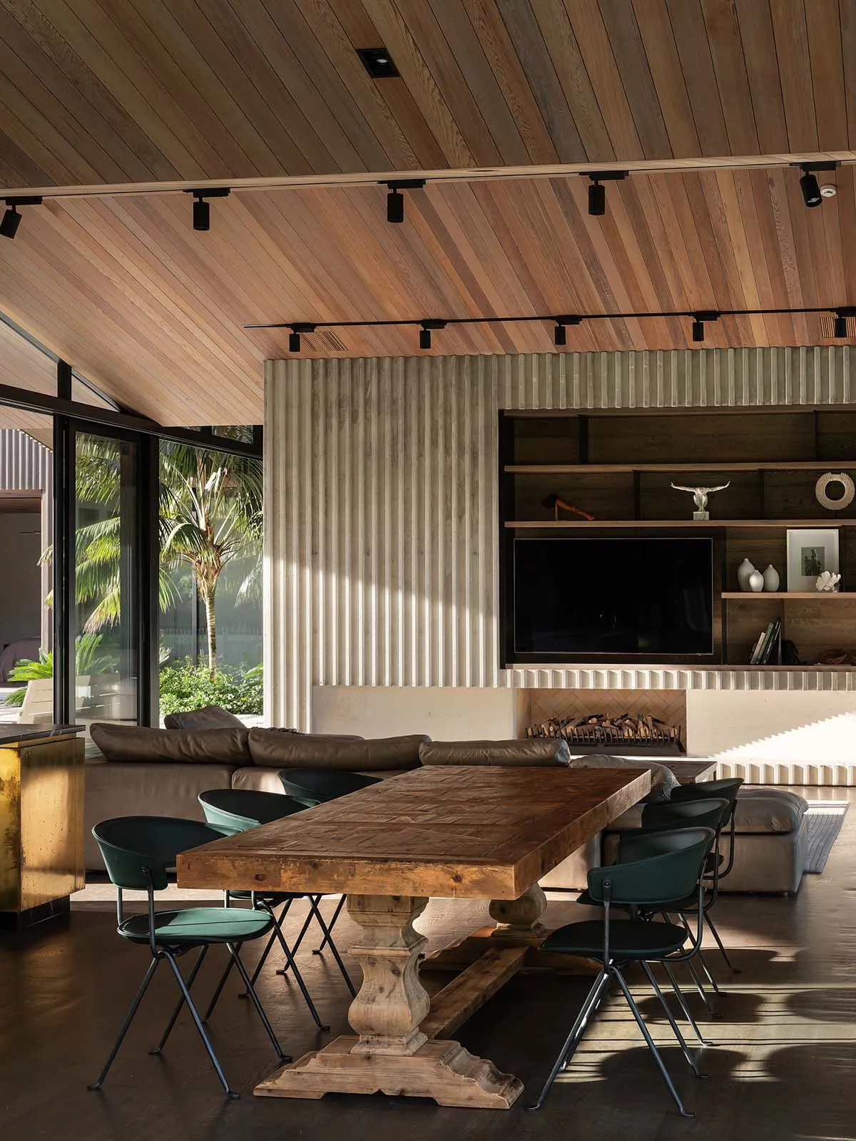 Modern industrial living room with wooden furniture and corrugated metal accent wall.