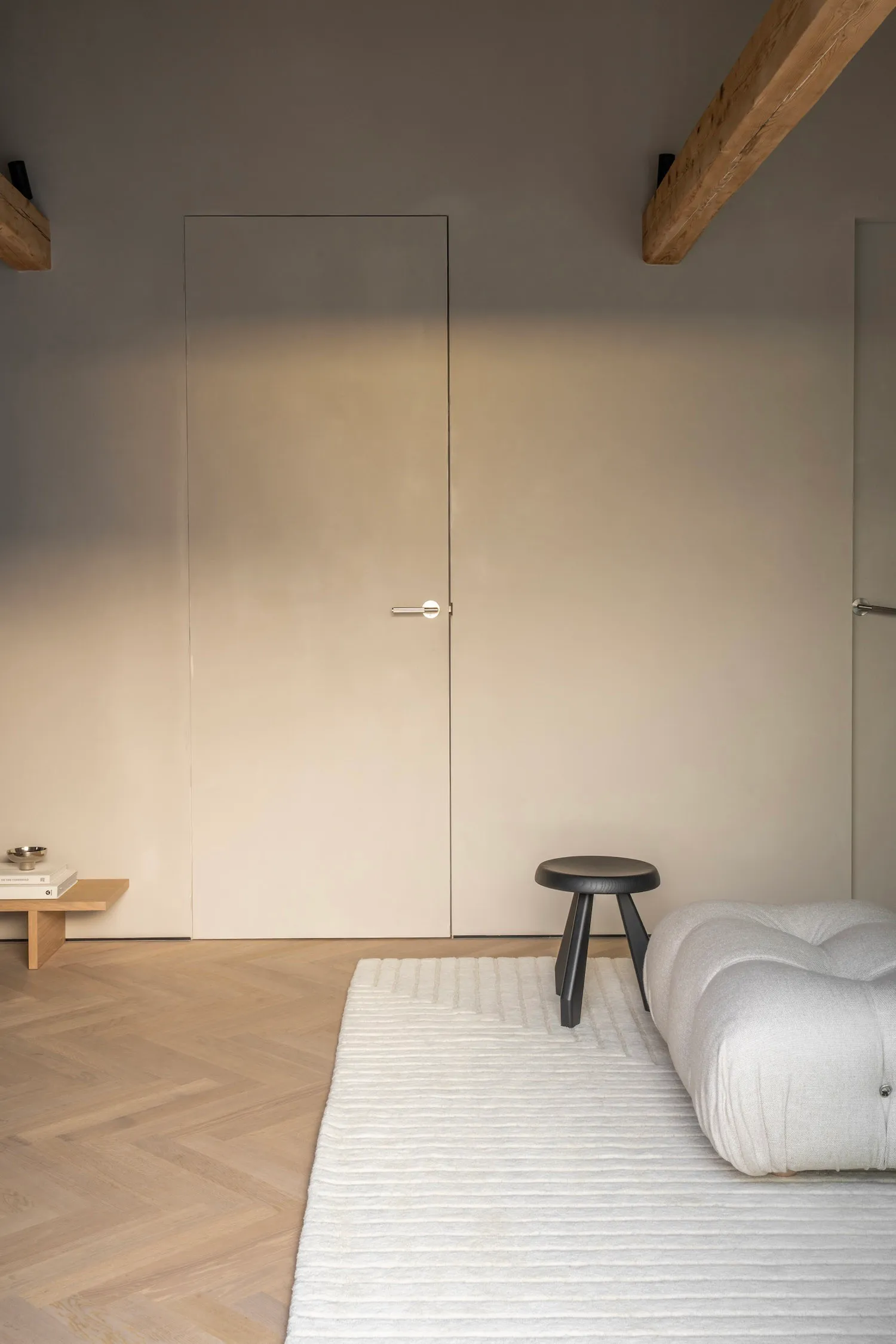A minimalist living room with wooden furniture and a neutral color palette.