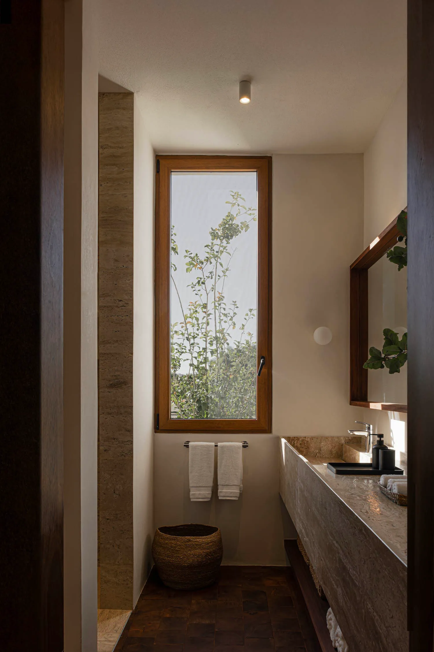 Bathroom interior with modern design, stone construction, and natural light.